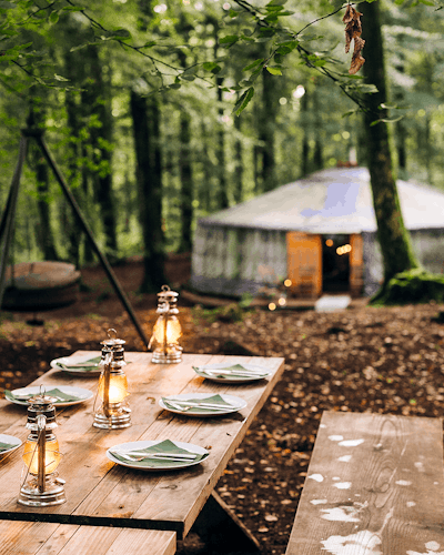 dukat bord utomhus i skogen och en jurta